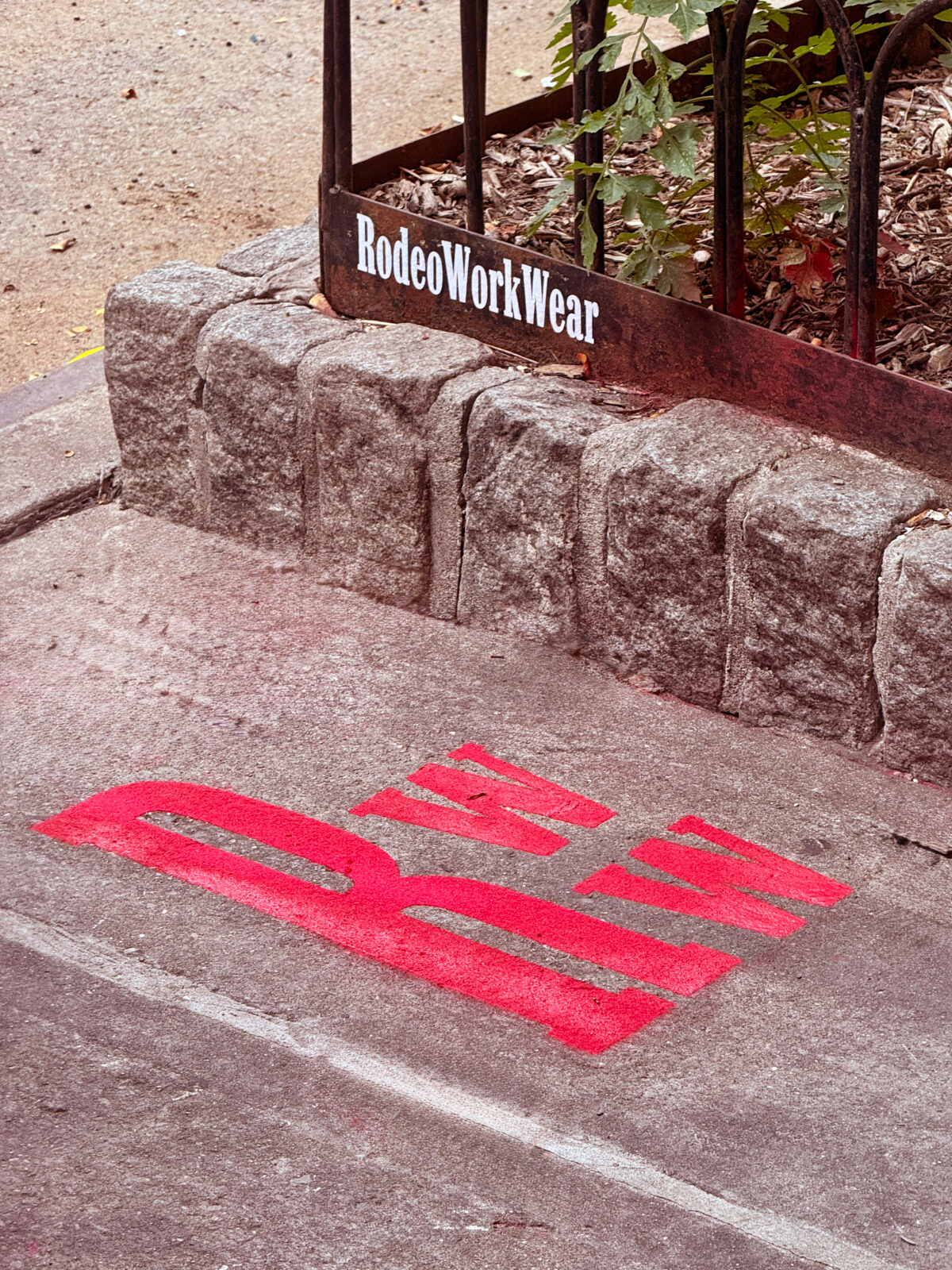 RodeoWorkWear branded curb stencil outside the storefront